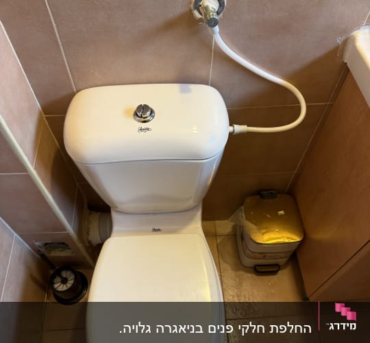 אסלה עם חיבורי מים בחדר אמבטיה